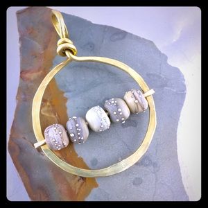 Glass, sterling silver, and brass pendant